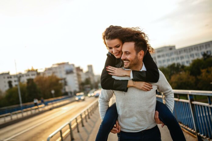 Happy young couple embracing laughing on date Happy young couple embracing laughing on date