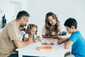 parents helping children with homework at table at home