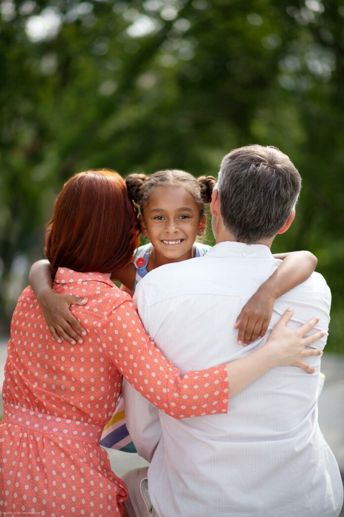 Dark-eyed African-American girl meeting her adoptive parents Dark-eyed African-American girl meeting her adoptive parents