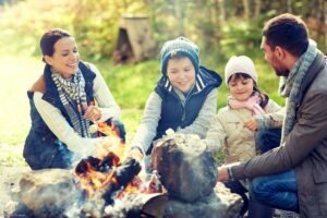 happy family roasting marshmallow over campfire