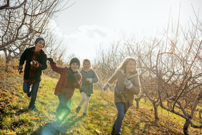 Four children running outdoors in winter Four children running outdoors in winter